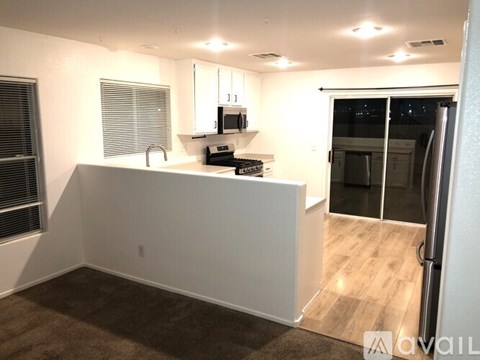 A kitchen area with a white counter and a refrigerator.