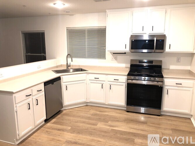 A kitchen with white cabinets and a black oven.