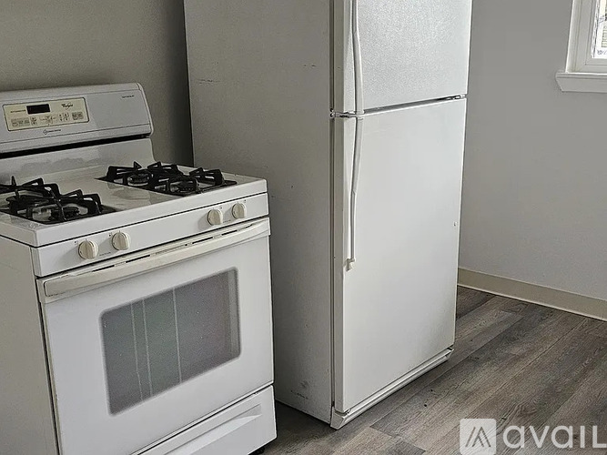 A white gas stove and refrigerator in a kitchen.
