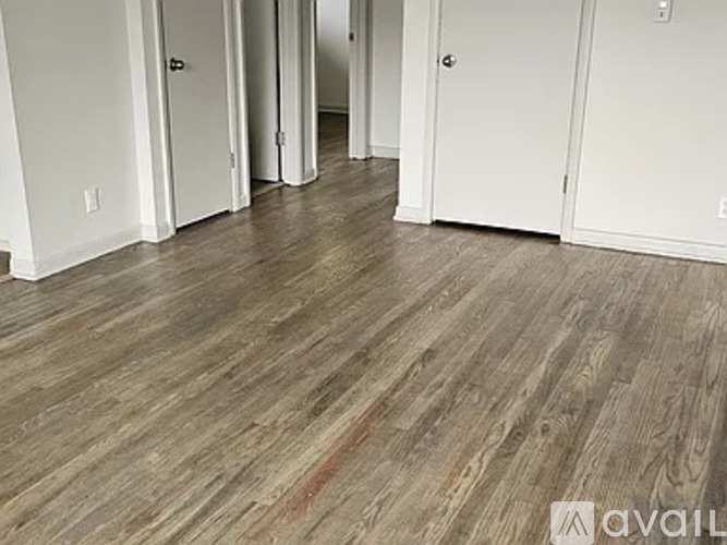 A room with wood flooring and white walls.