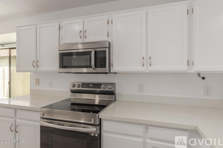 A kitchen with white cabinets and a stainless steel oven.