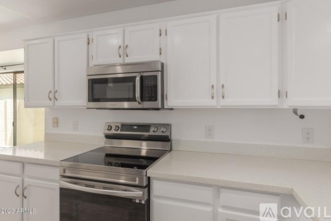 A kitchen with white cabinets and a stainless steel oven.