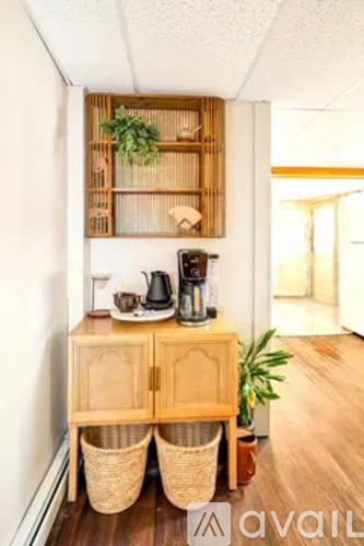 A wooden cabinet with two baskets underneath it and a shelf above it with plants on it.