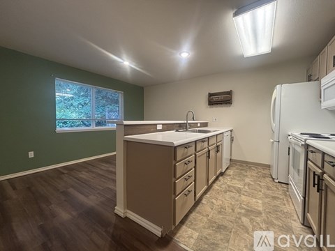A kitchen with white appliances and wooden cabinets.