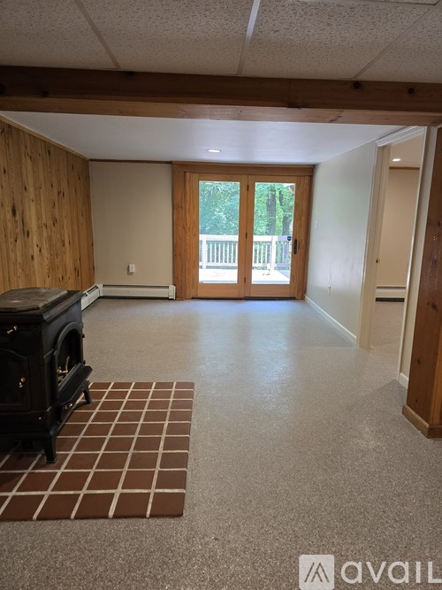 A living room with a wood paneled wall and a wood floor.
