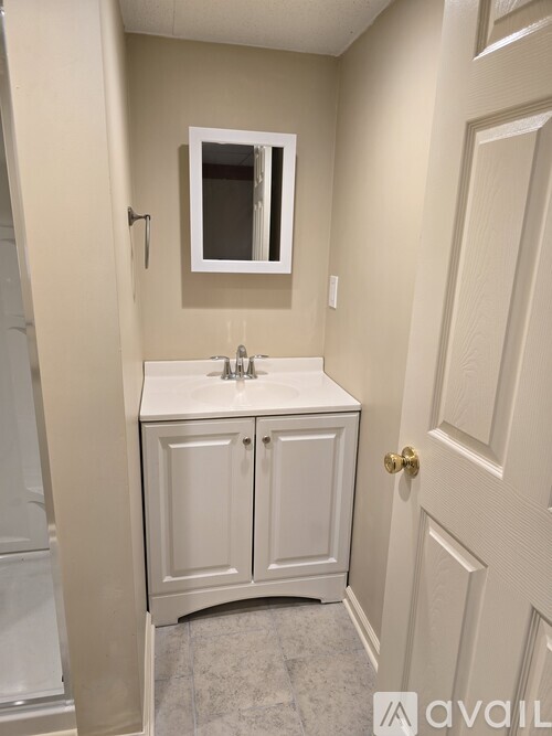 A bathroom with a white sink and cabinet.