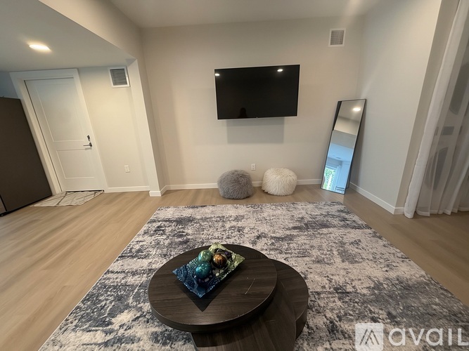 A living room with a flat screen TV mounted on the wall above a coffee table.