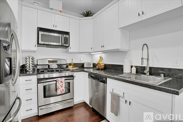 A modern kitchen with white cabinets and stainless steel appliances.