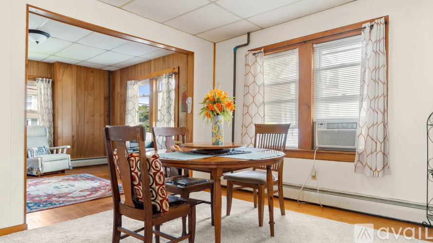 A dining room with a wooden table and chairs.