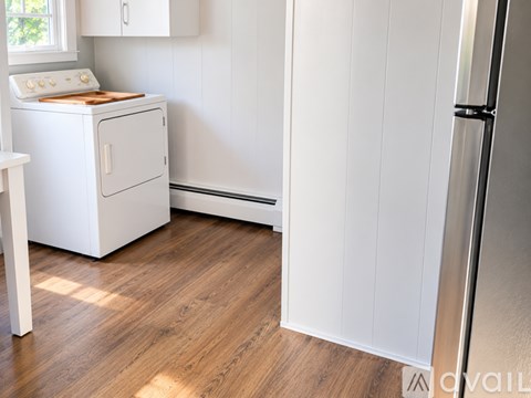 A white oven and stove top are in a kitchen with a wooden floor.