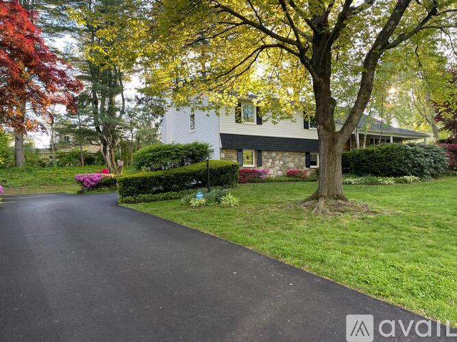 A house with a driveway and trees in the background.