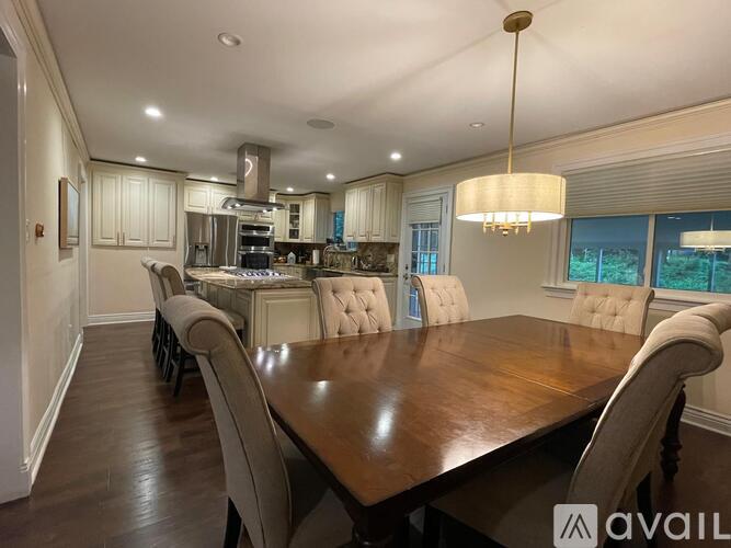 A well-lit dining room with a large table and chairs.