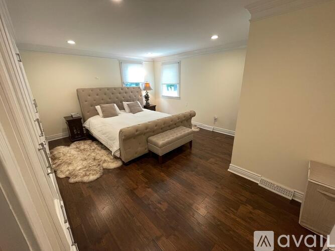 A bedroom with a large bed and a wooden floor.