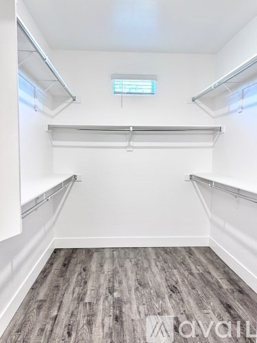 A spacious room with a wooden floor and white walls.