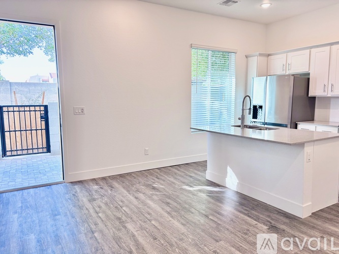 A kitchen with white cabinets and a white island with a sink.