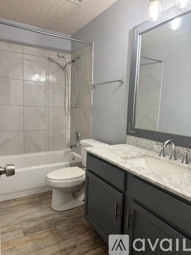 A bathroom with a toilet, sink, and shower.