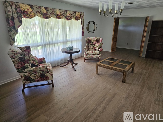A living room with floral chairs and a round table.