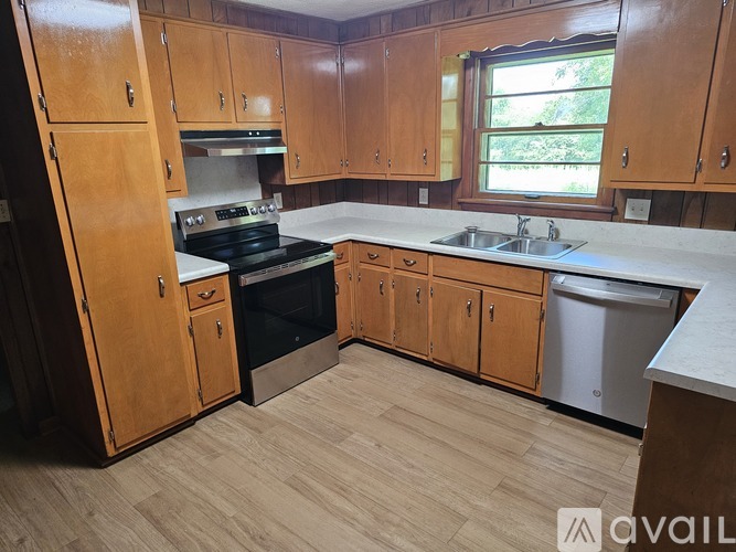 A kitchen with wooden cabinets and a black stove top oven.