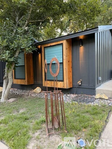 A modern house with a wooden exterior and a large circular window.