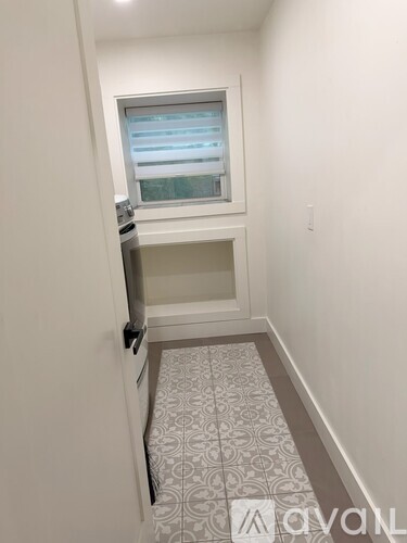 A small room with a window and a tiled floor.