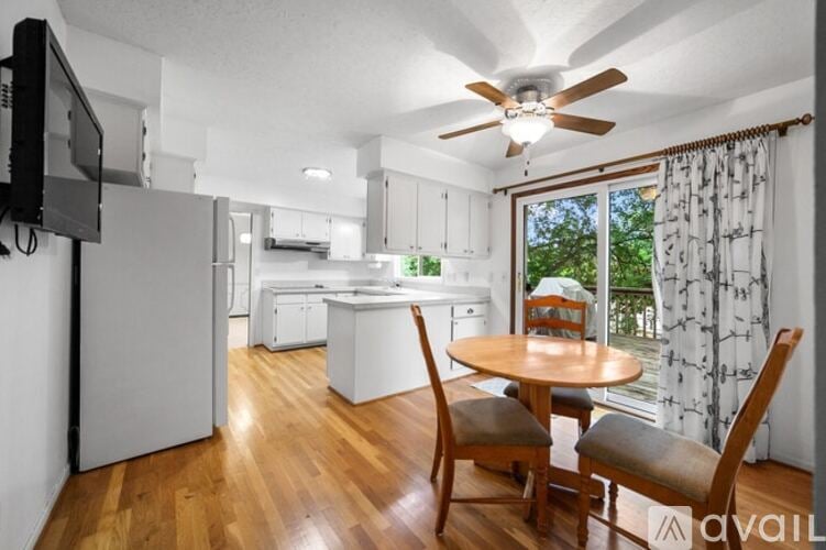 A kitchen with a table and chairs in front of a window.