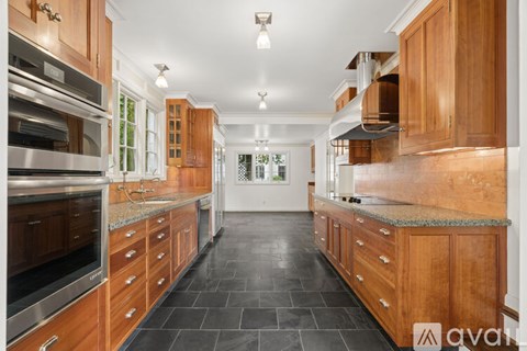 A kitchen with wooden cabinets and a marble countertop.