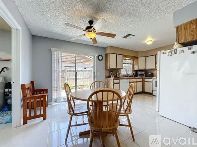 A kitchen with a dining table and chairs.