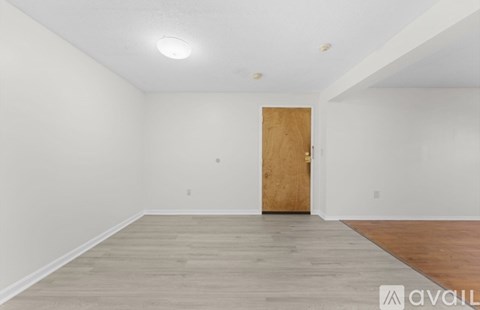 A room with a wooden door and a wooden floor.