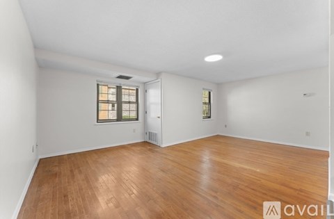 A room with wooden flooring and a window with blinds.