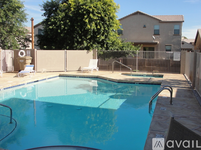 A pool with a metal fence and a house in the background.