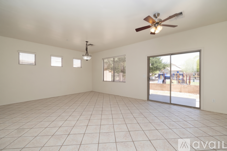 A spacious room with a ceiling fan and sliding glass doors.