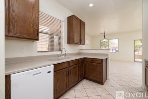 A kitchen with wooden cabinets and a white dishwasher.