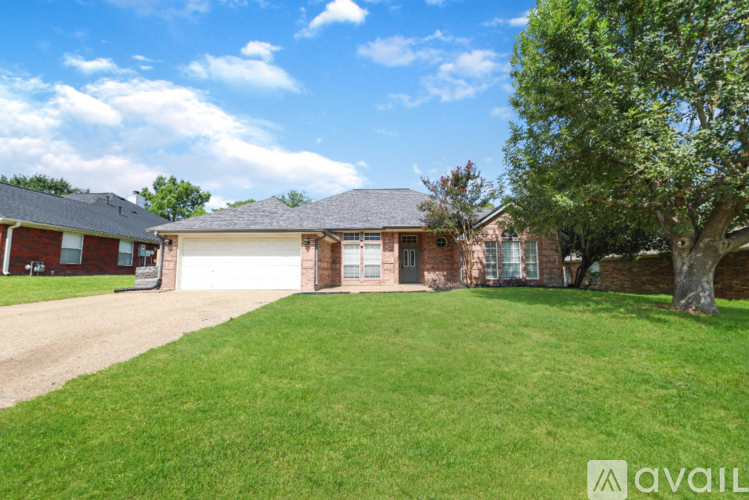 A house with a large lawn and a tree in front.