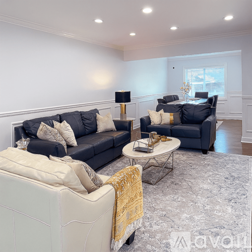 A living room with a dark blue sofa and a white armchair.