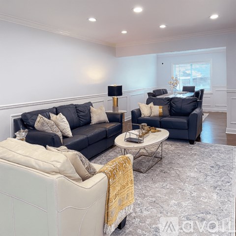 A living room with a dark blue sofa and a white armchair.