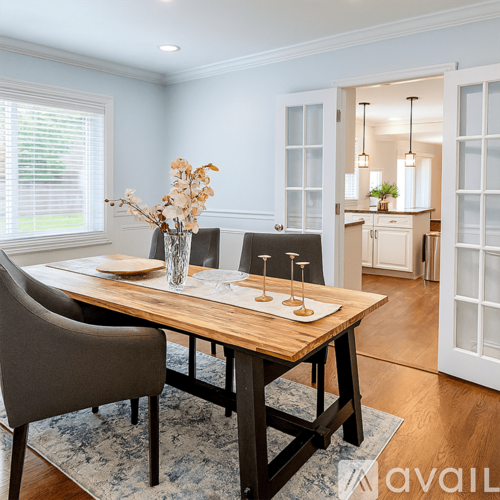 A dining room with a wooden table and chairs.