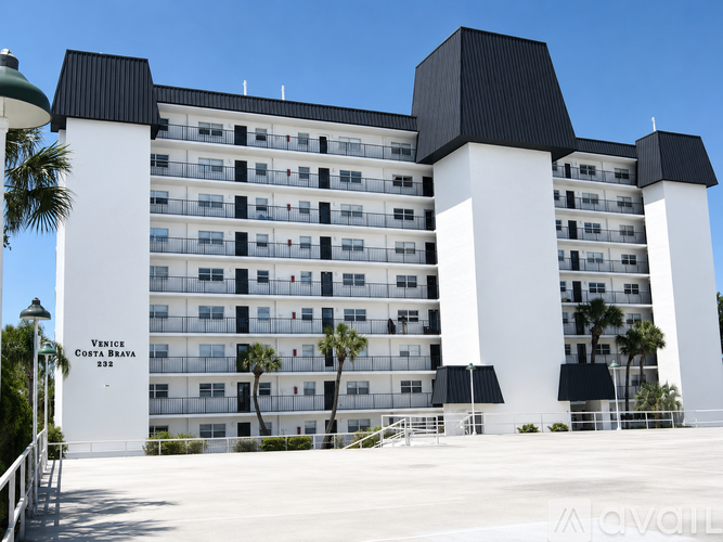 A large white building with black roofs and a sign that reads Venice Costa Brava 333.