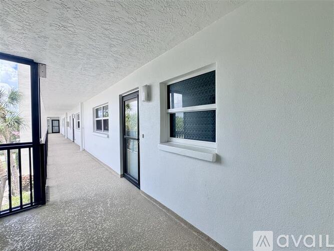 A long hallway with a black gate and white walls.