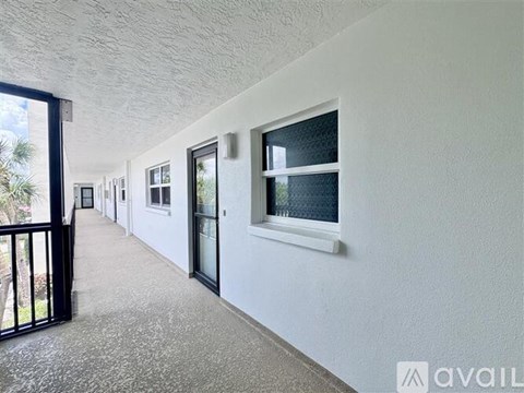 A long hallway with a black gate and white walls.