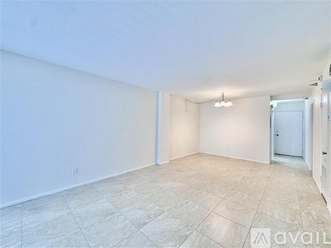 A spacious room with tiled flooring and white walls.