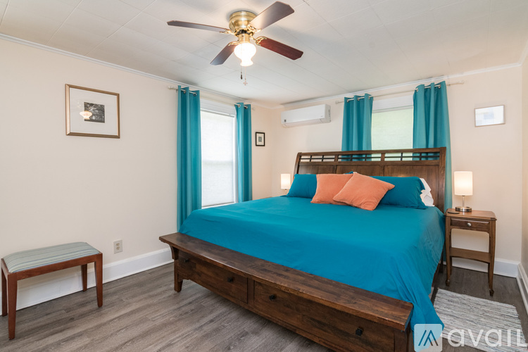 A bedroom with a blue bedspread and a wooden bed.