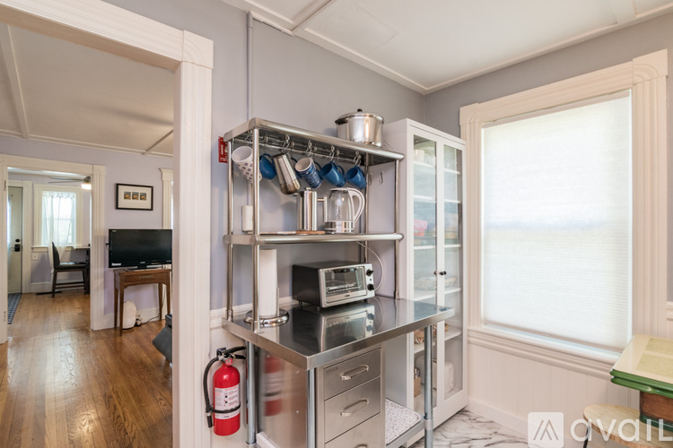 A kitchen with a stainless steel refrigerator and a red fire extinguisher.