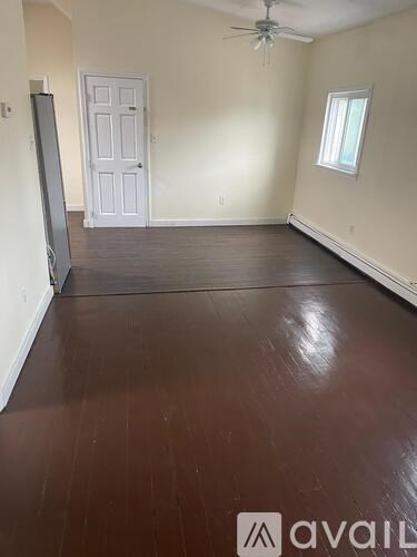 A room with wooden flooring and a ceiling fan.