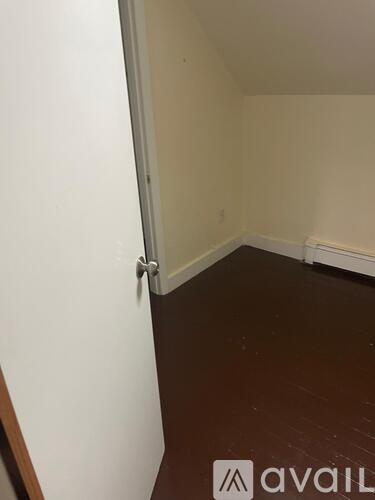 A room with a brown floor and white walls.