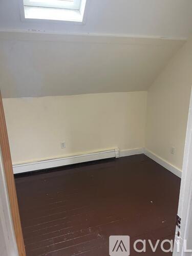 A room with a wooden floor and a window.