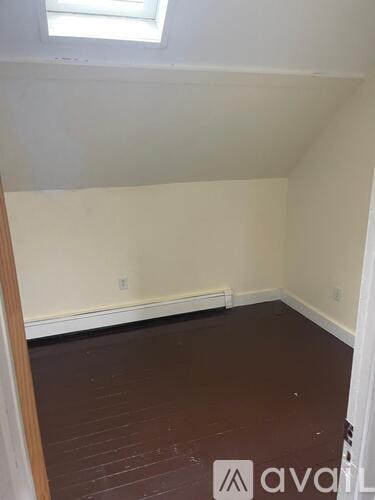 A room with a wooden floor and a window.