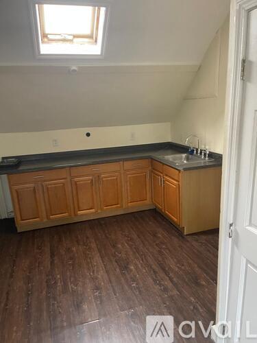 A kitchen with wooden cabinets and a skylight.
