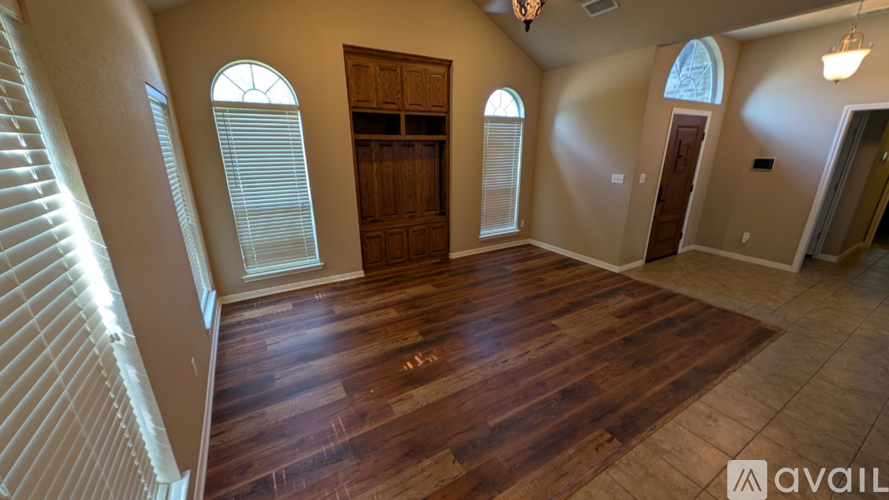 A room with wooden floors and a large wooden door.
