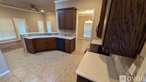 A kitchen with a large island and wooden cabinets.