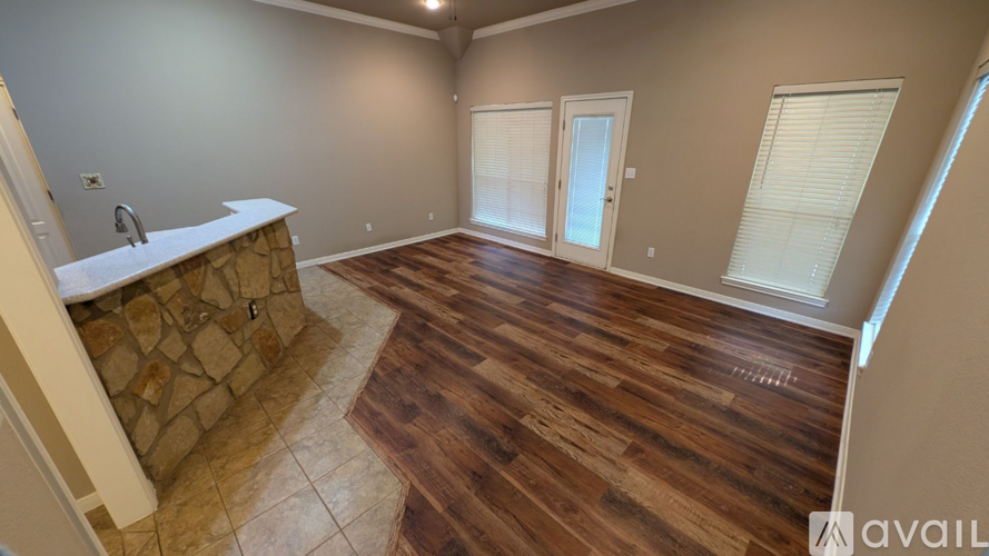 A room with wooden flooring and a stone countertop.